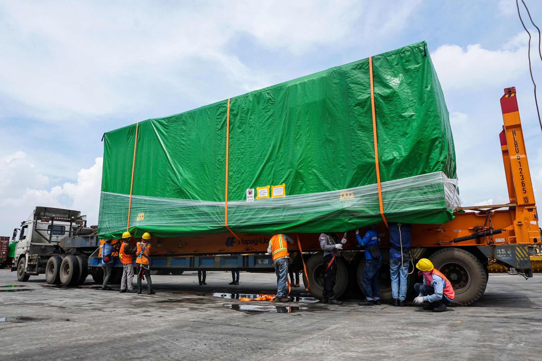 Heavy truck and trailer carrying a large secured industrial load in Jakarta